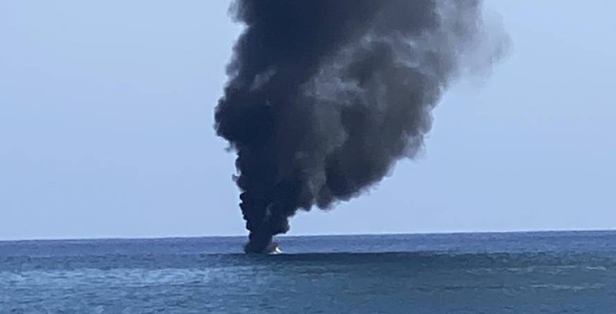 Barco em chamas com quatro pessoas no interior