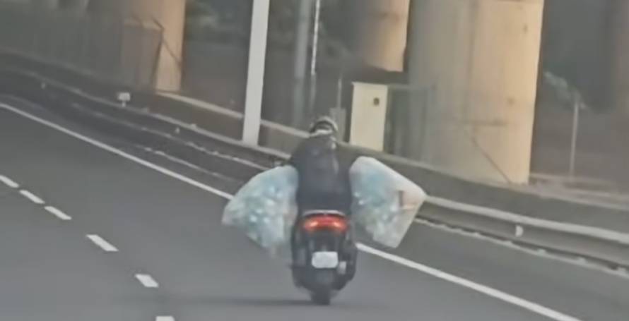 Motociclista arrisca na via rápida com sacos cheios de embalagens para receber caução do Sistema Volta