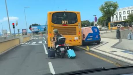 Turistas vistos a transportarem malas enquanto andam de mota