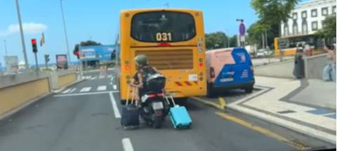Turistas vistos a transportarem malas enquanto andam de mota