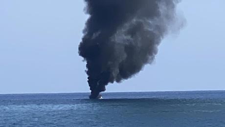 Barco em chamas com quatro pessoas no interior
