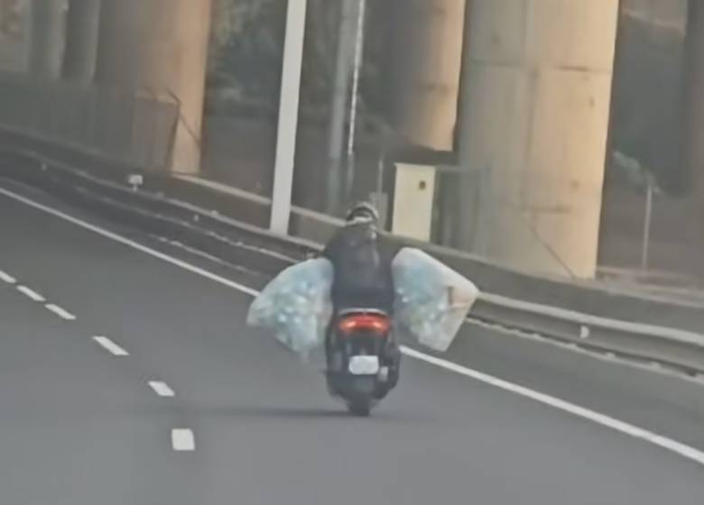 Motociclista arrisca na via rápida com sacos cheios de embalagens para receber caução do Sistema Volta