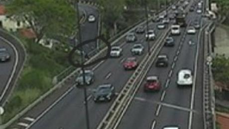 Duas turistas a andarem a pé na via rápida e a filmarem