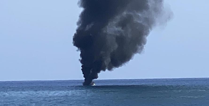 Barco em chamas com quatro pessoas no interior